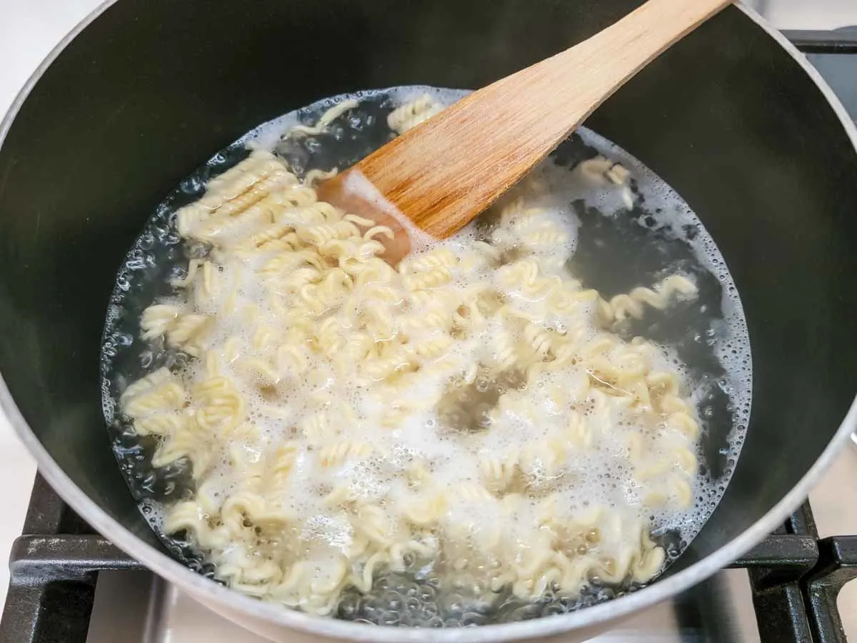 ramen noodles boiling in a pan.