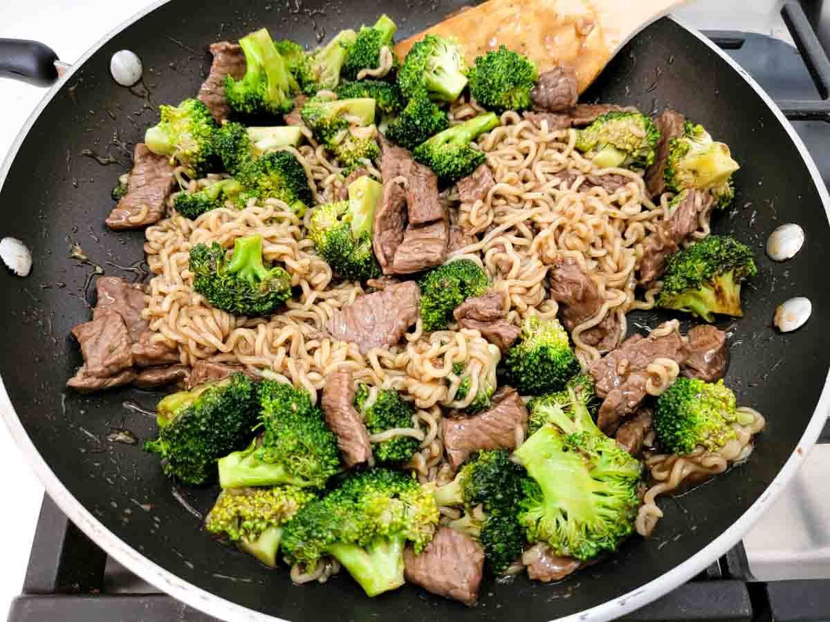 a large frying pan filled with ramen beef and broccoli.