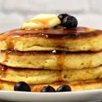 a stack of 4 fluffy pancakes on a plate.