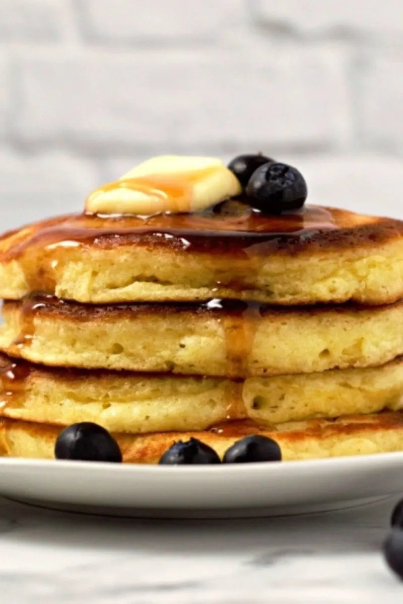 a stack of 4 fluffy pancakes on a plate.
