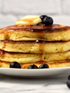 a stack of 4 fluffy pancakes on a plate.