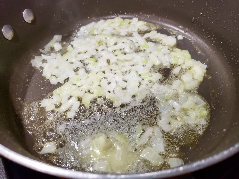 butter and onions cooking in a pan.