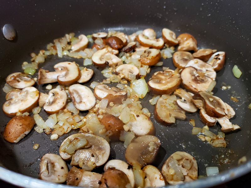 mushrooms and garlic cooking in a pan.