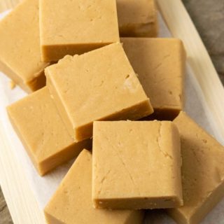 Peanut Butter Fudge stacked on a cutting board.