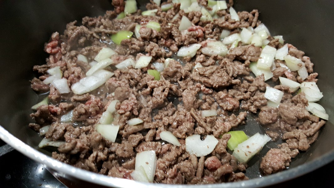 ground beef and onion cooking in a skillet.