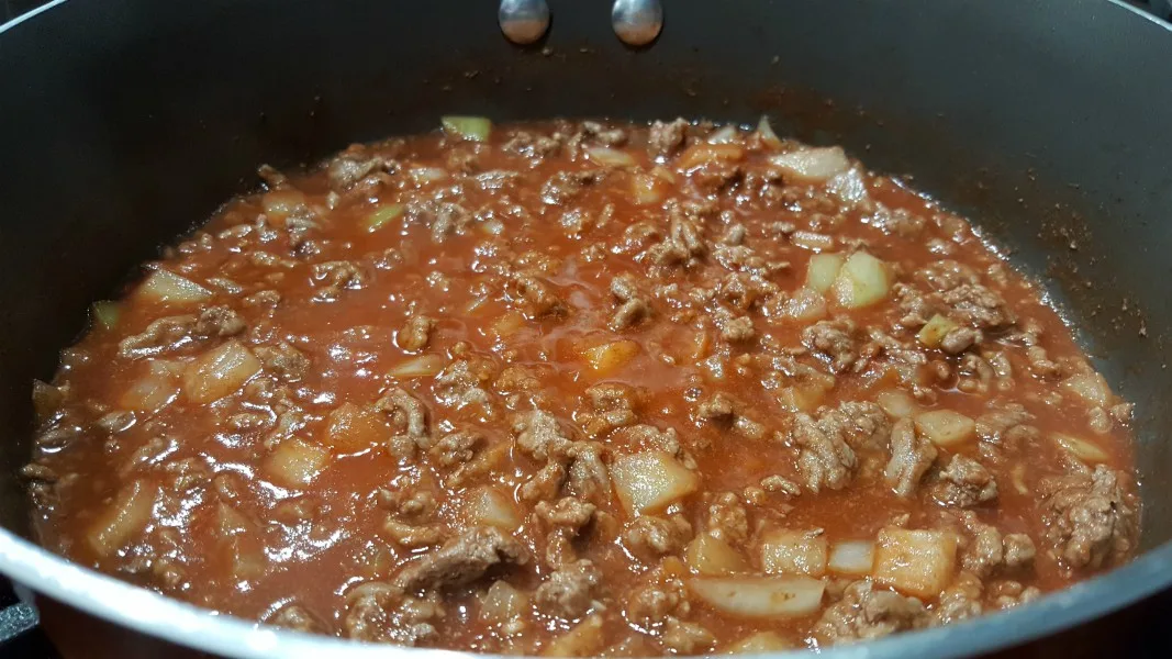 ground beef, onion, minced garlic, tomato paste, water, Worcestershire sauce, brown sugar and salt cooking in a skillet.