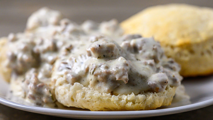 Skillet Sausage Gravy over biscuits on a plate.