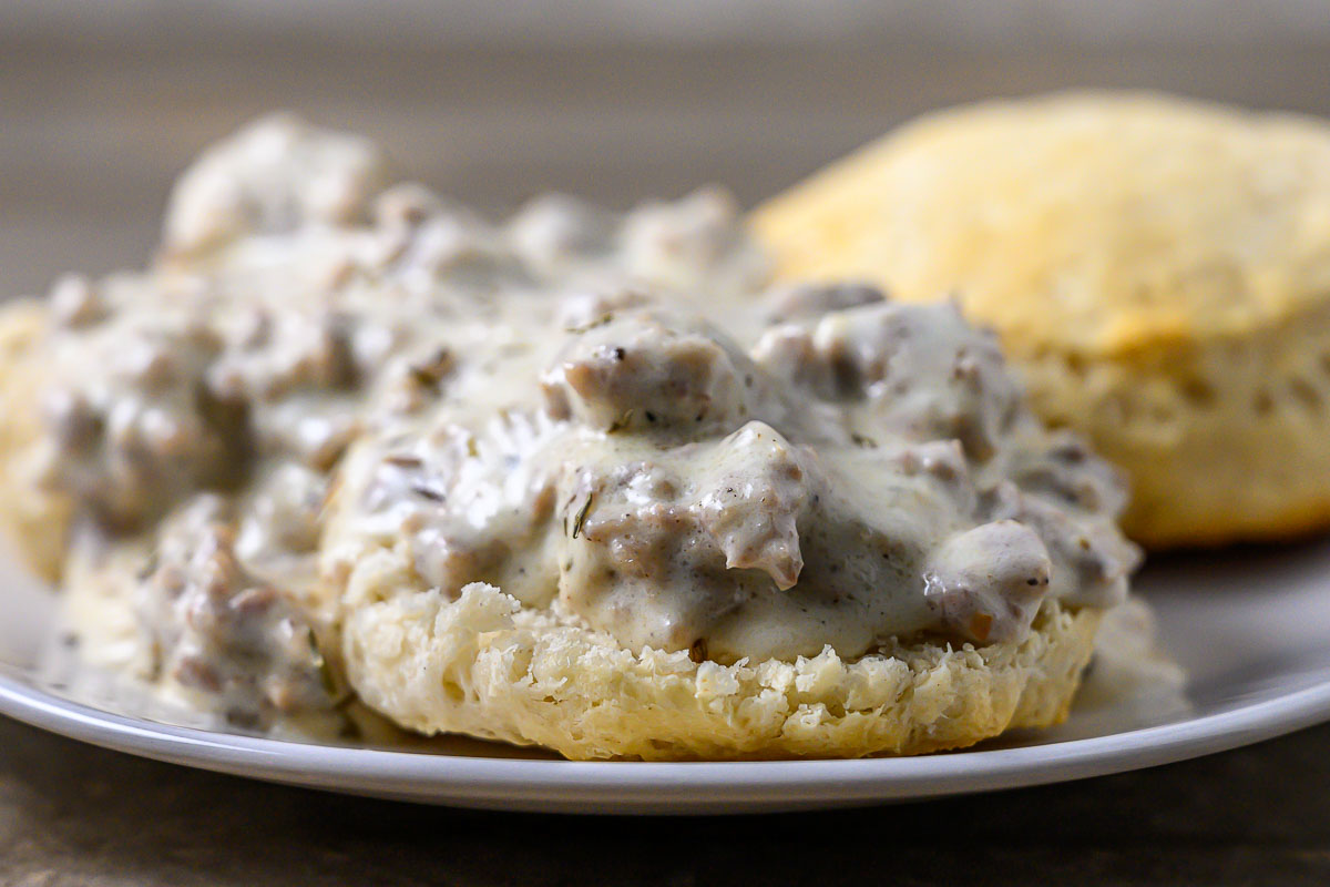 Skillet Sausage Gravy over biscuits on a plate.