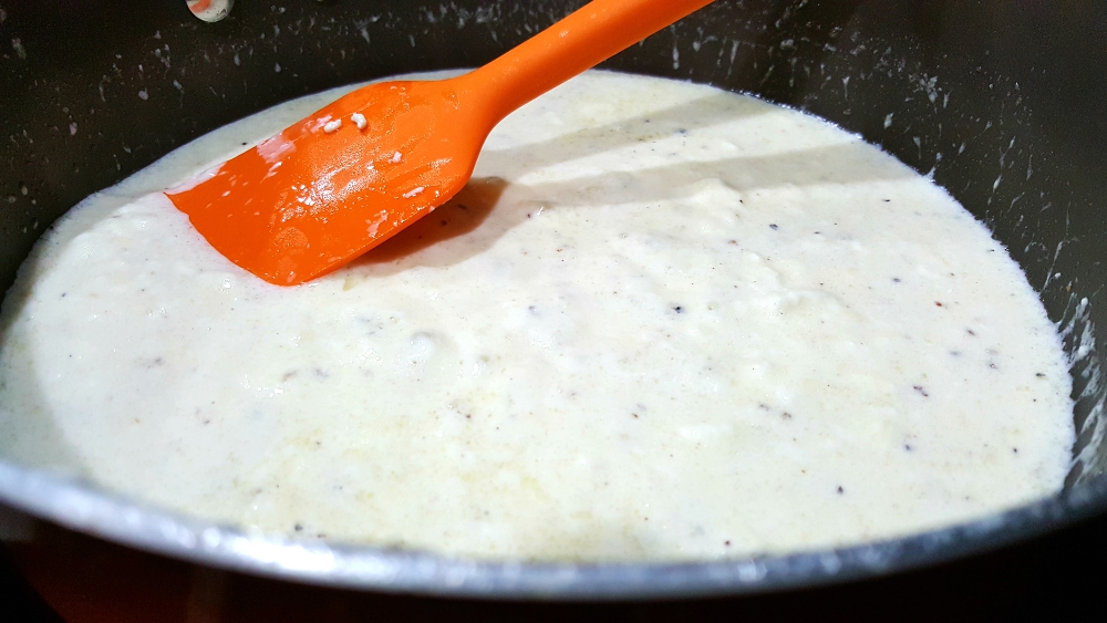 alfredo sauce cooking in a pan.