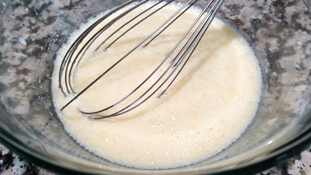 egg yolks, milk, oil, and vanilla whisked in a bowl.