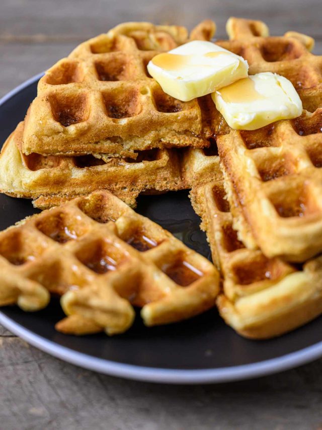 Thick and Fluffy Waffles stacked on a plate.