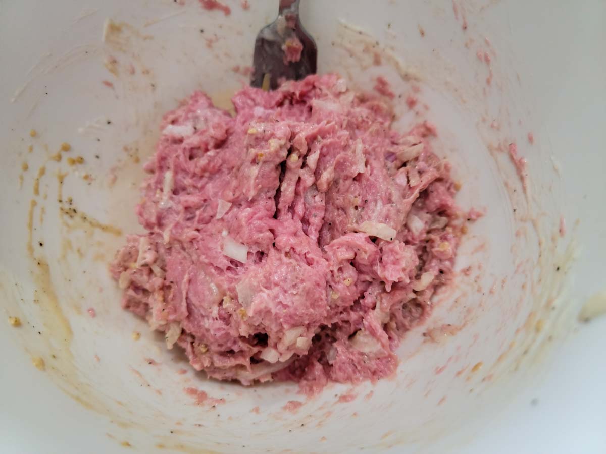 ground turkey mixed with onions and seasonings in a bowl.