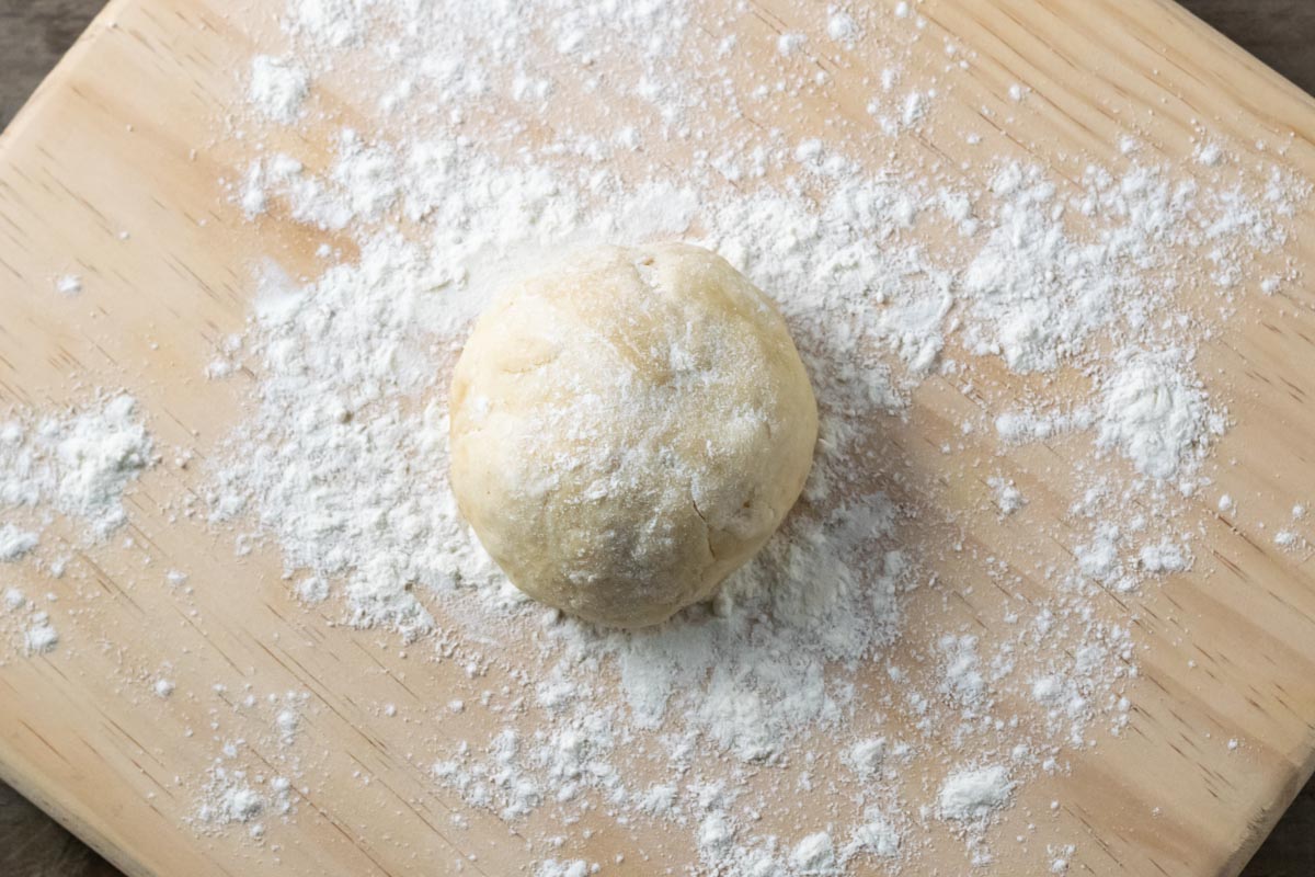 a ball of dough on a floured cutting board.