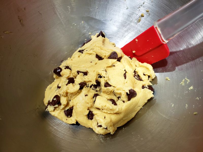 chocolate chips added to cookie dough in a stand mixer bowl.