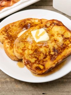 15 Minute Texas French Toast slices on a plate topped with butter and syrup.