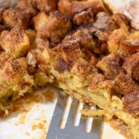 French Toast Casserole Brioche with a spatula in a baking dish.