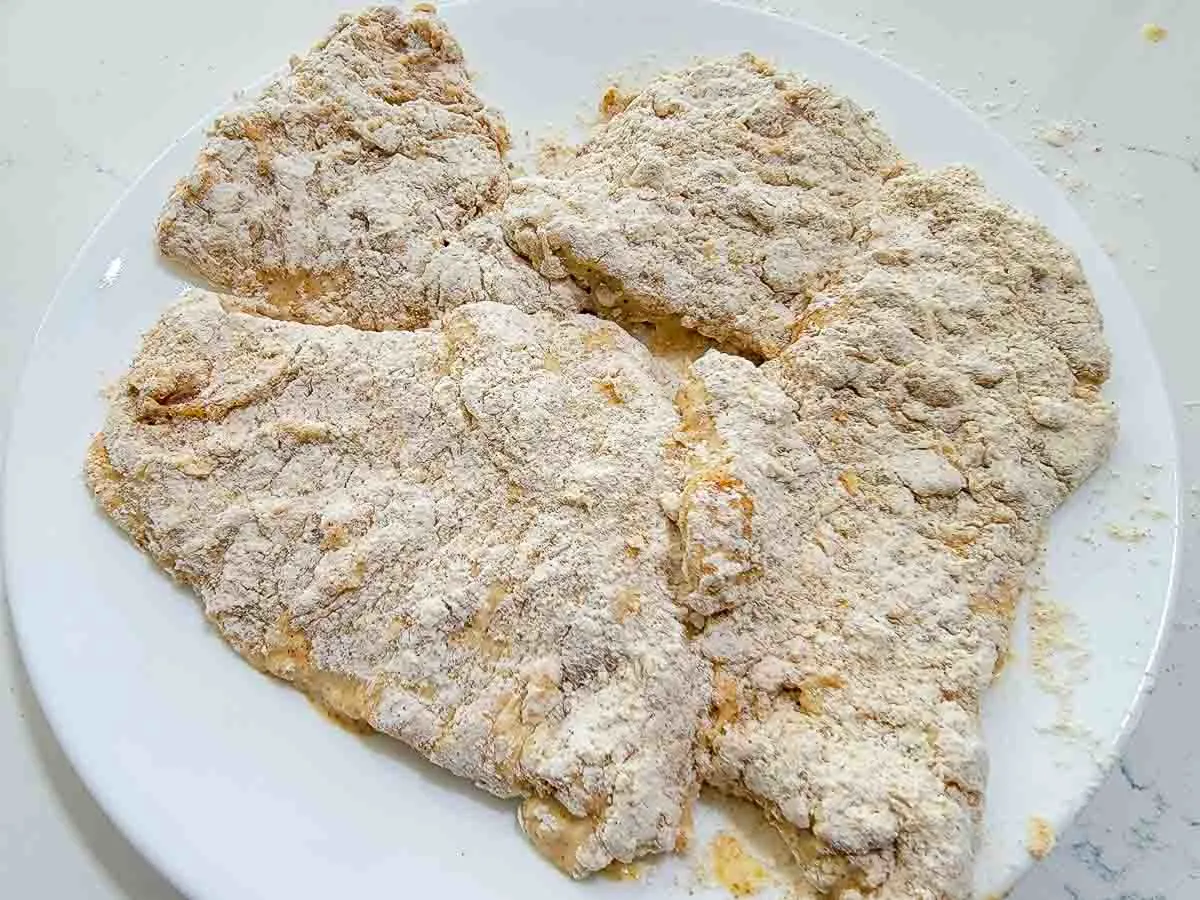 chicken coated with seasoning and flour mixture.