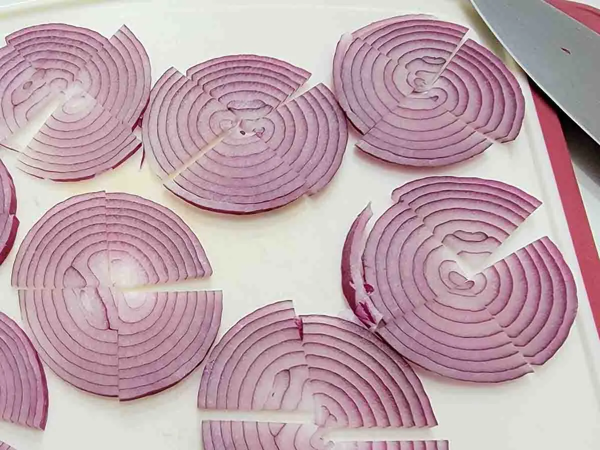 sliced red onions on a cutting board.