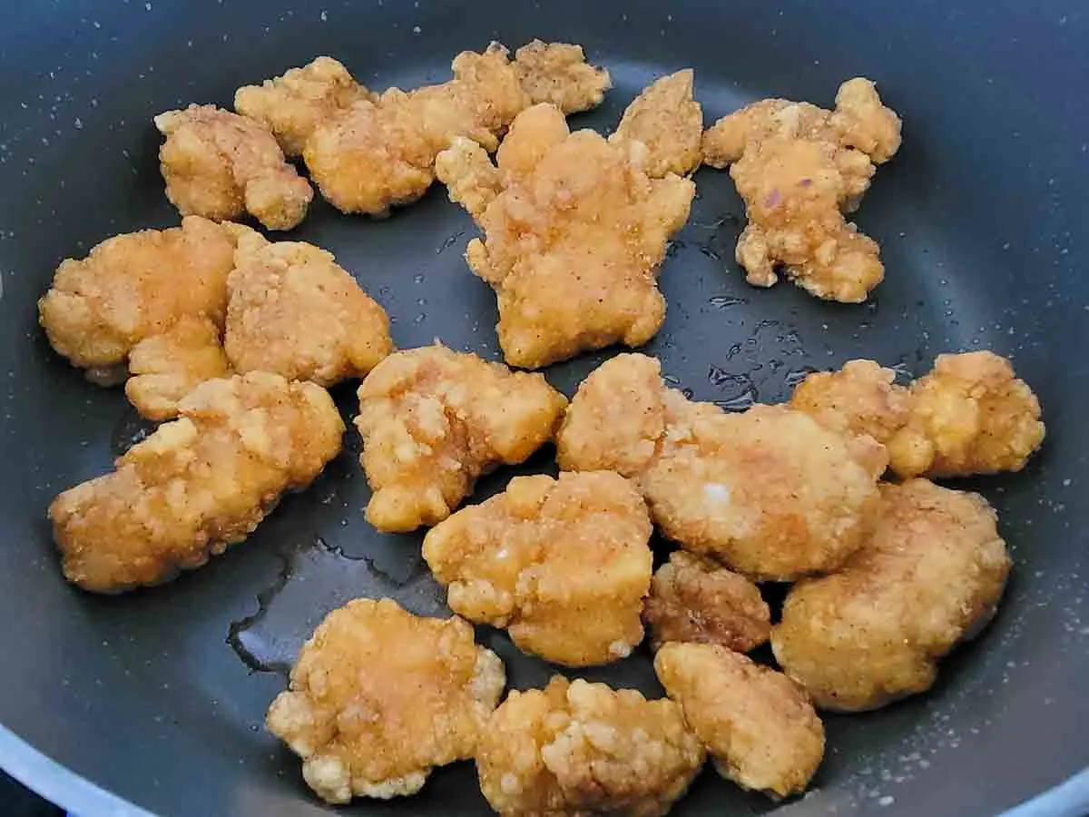 chicken nuggets cooking in a skillet.