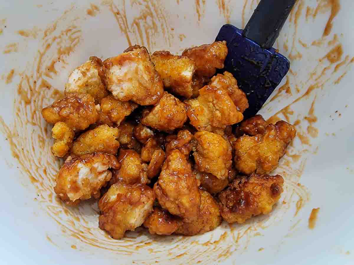 popcorn chicken coated in bbq sauce in a bowl.