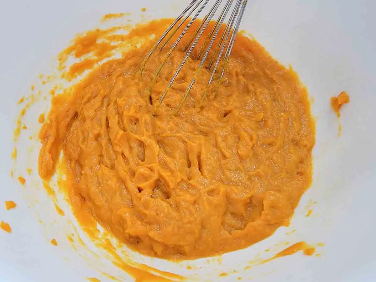eggs and pumpkin puree whisked in a bowl.