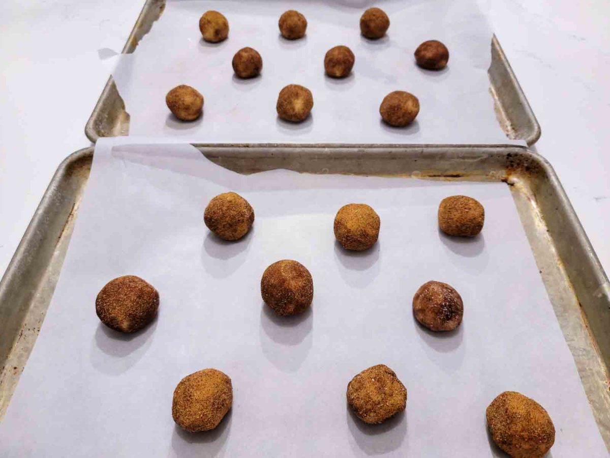 toffee doodle cookies rolled into balls and ready to bake on cookie sheets.