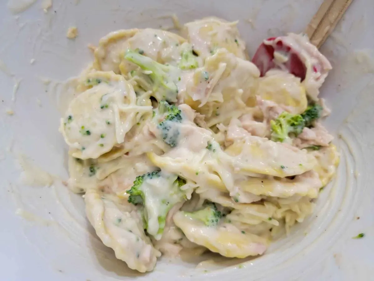 ravioli, shredded chicken, broccoli, Alfredo sauce, and heavy cream in a large bowl.
