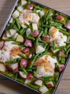 Italian Dressing Chicken on a sheet pan filled with boneless chicken, red potatoes and green beans.