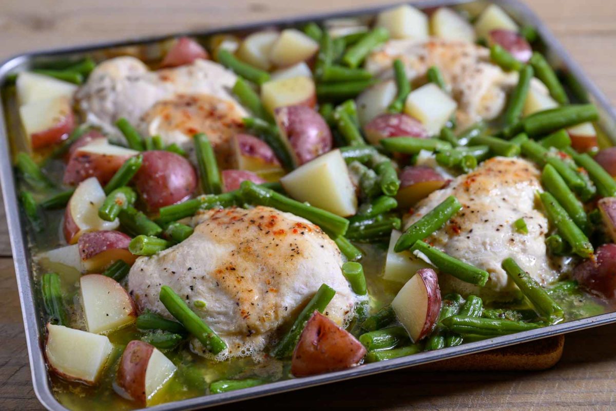 Italian Chicken Green Beans and Potatoes tray bake on a sheet pan filled with boneless chicken, red potatoes and green beans.