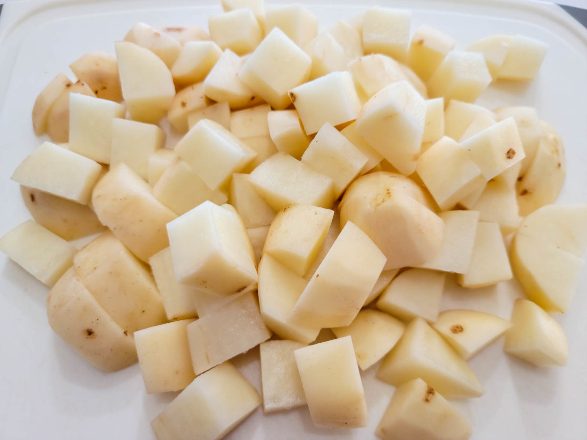 peeled and diced potatoes on a cutting board.