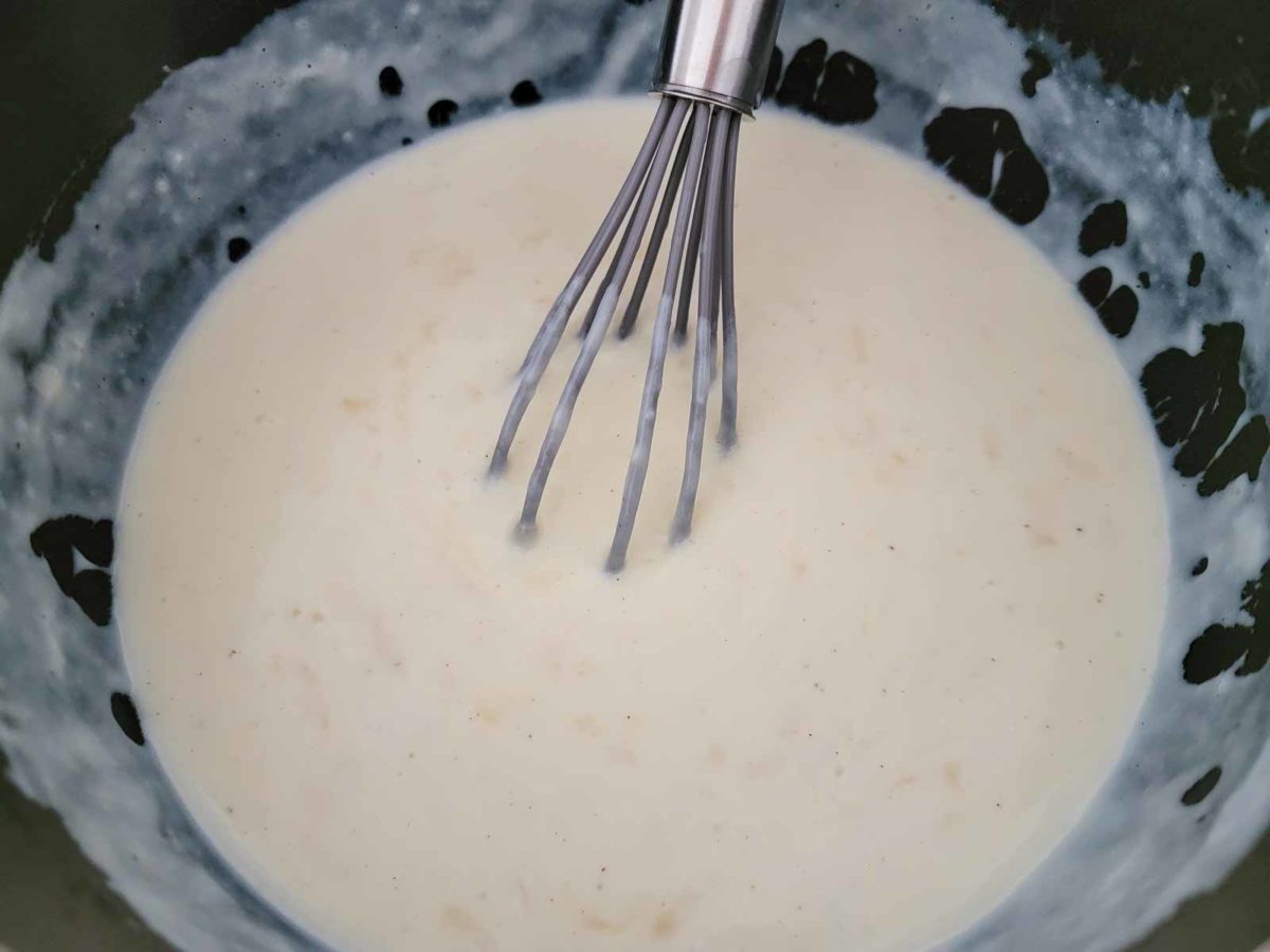 white cheddar cheese sauce cooking in a pan.
