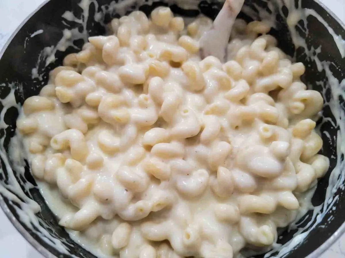 white cheddar macaroni and cheese cooking in a pan.