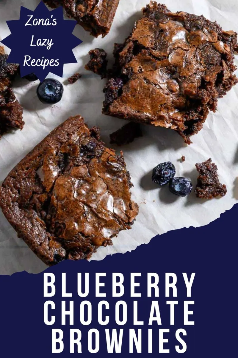 Chocolate Blueberry Brownies and fresh blueberries on parchment paper.