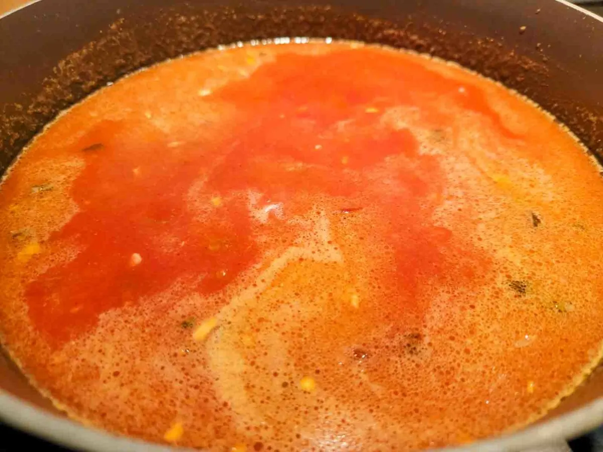 rice mix, salsa, water, garlic, and butter cooking in a pan.
