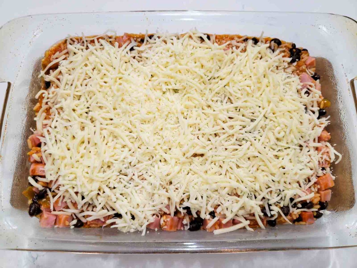Mexican Ham Casserole topped with shredded cheese in a casserole dish.
