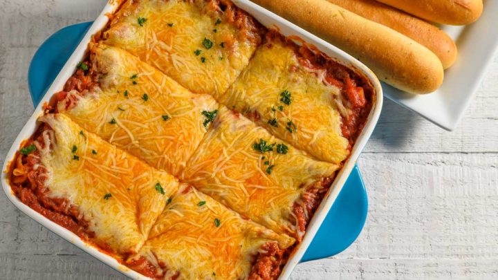 Lasagna Recipe with Ricotta Cheese and a side of breadsticks.