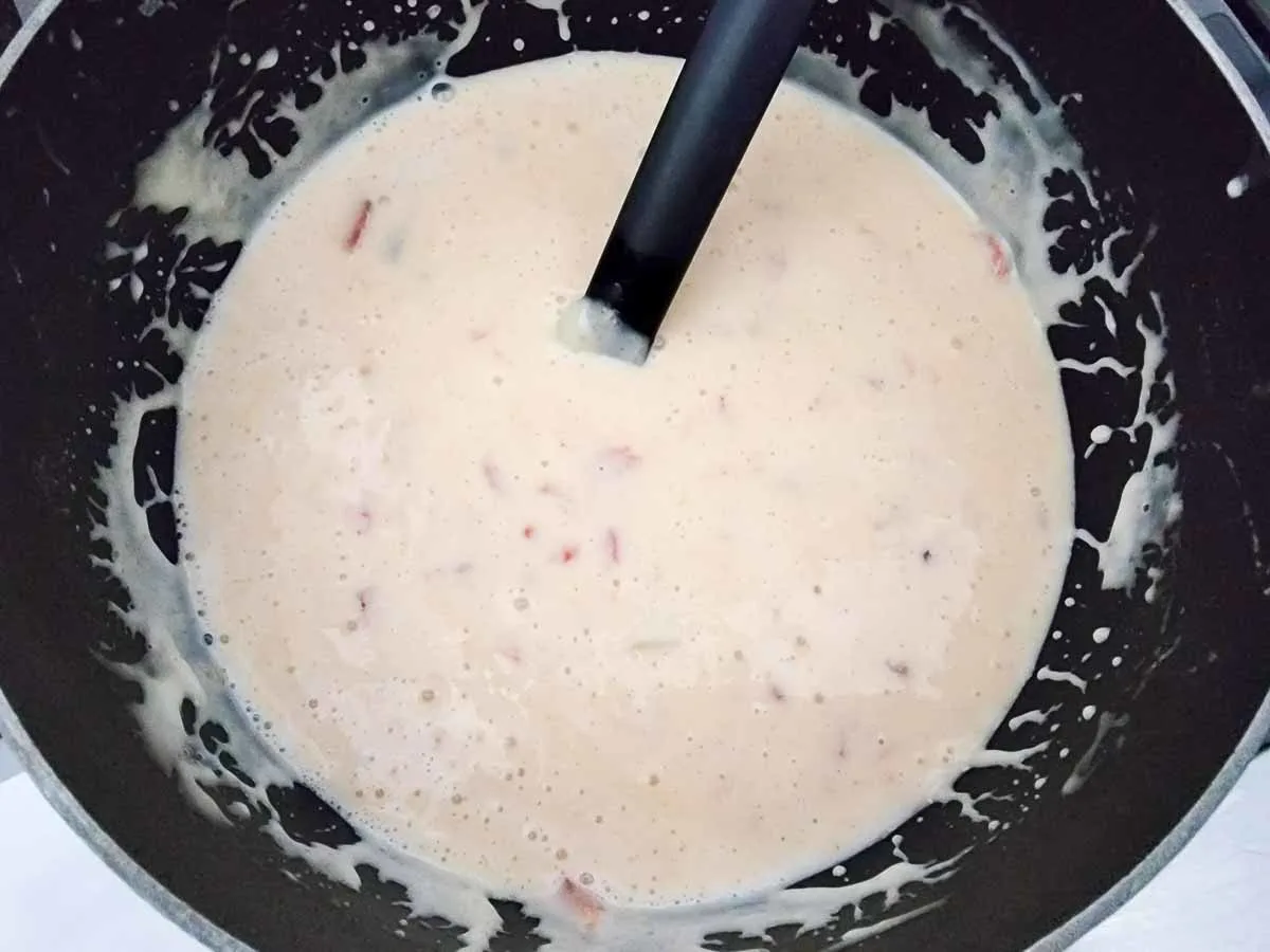 white queso with rotel tomatoes in a pan.