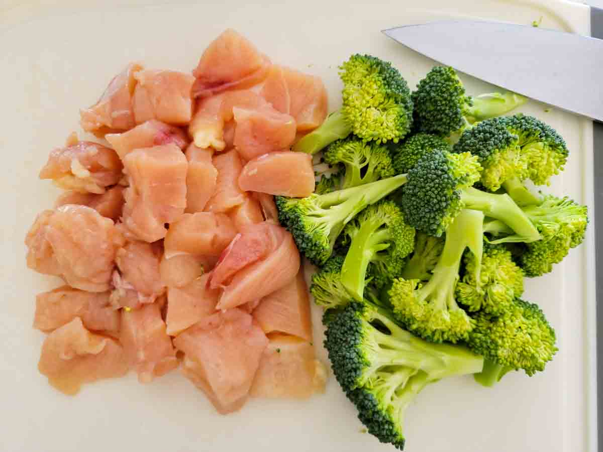 diced chicken and broccoli on a cutting board.