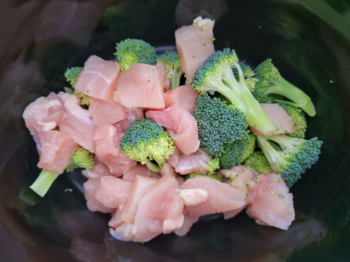 diced chicken and broccoli in a crock pot.