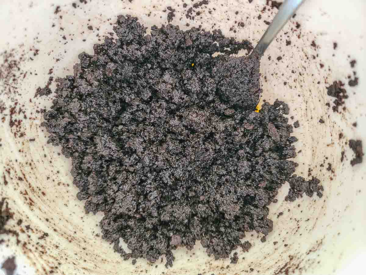 oreo crumbs and butter mixed in a bowl.
