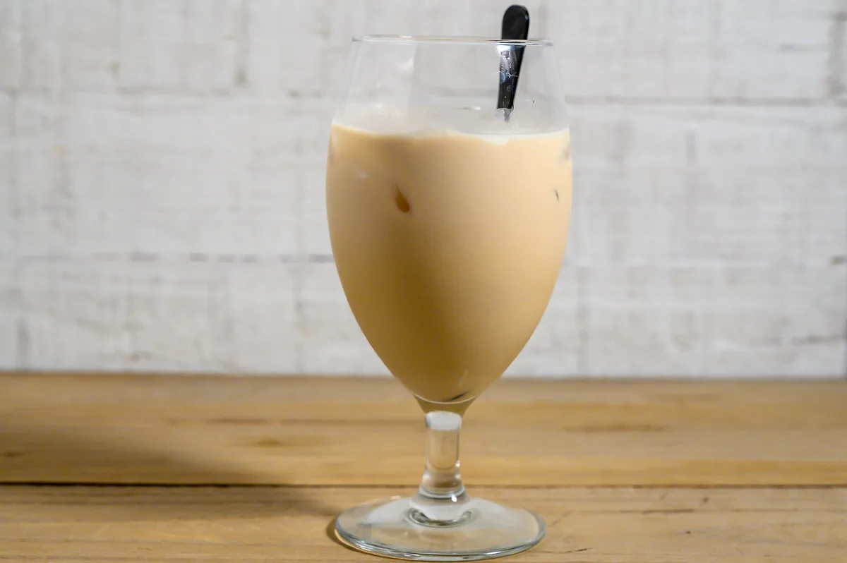 Skrewball White Russian in a glass with a spoon.