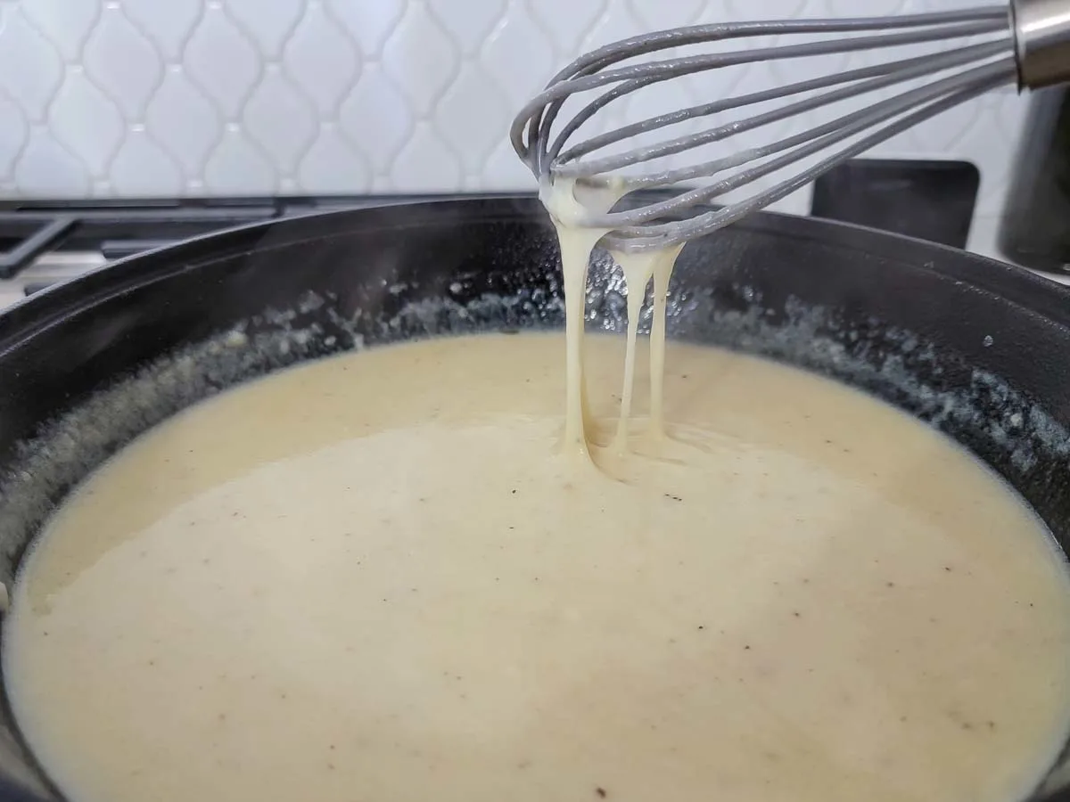cheese whisked into the flour and milk mixture in a skillet.