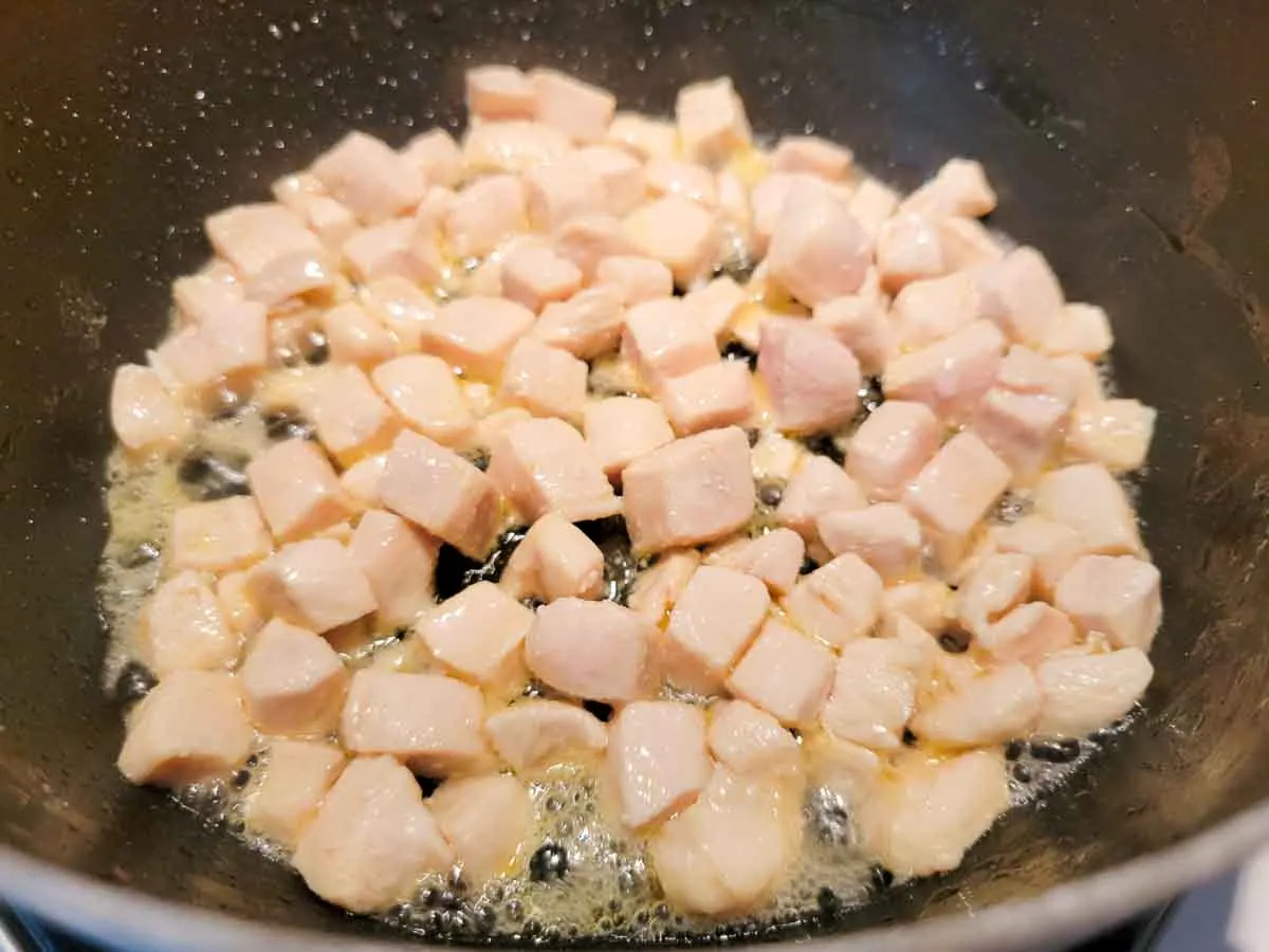 diced chicken cooking in a pan.