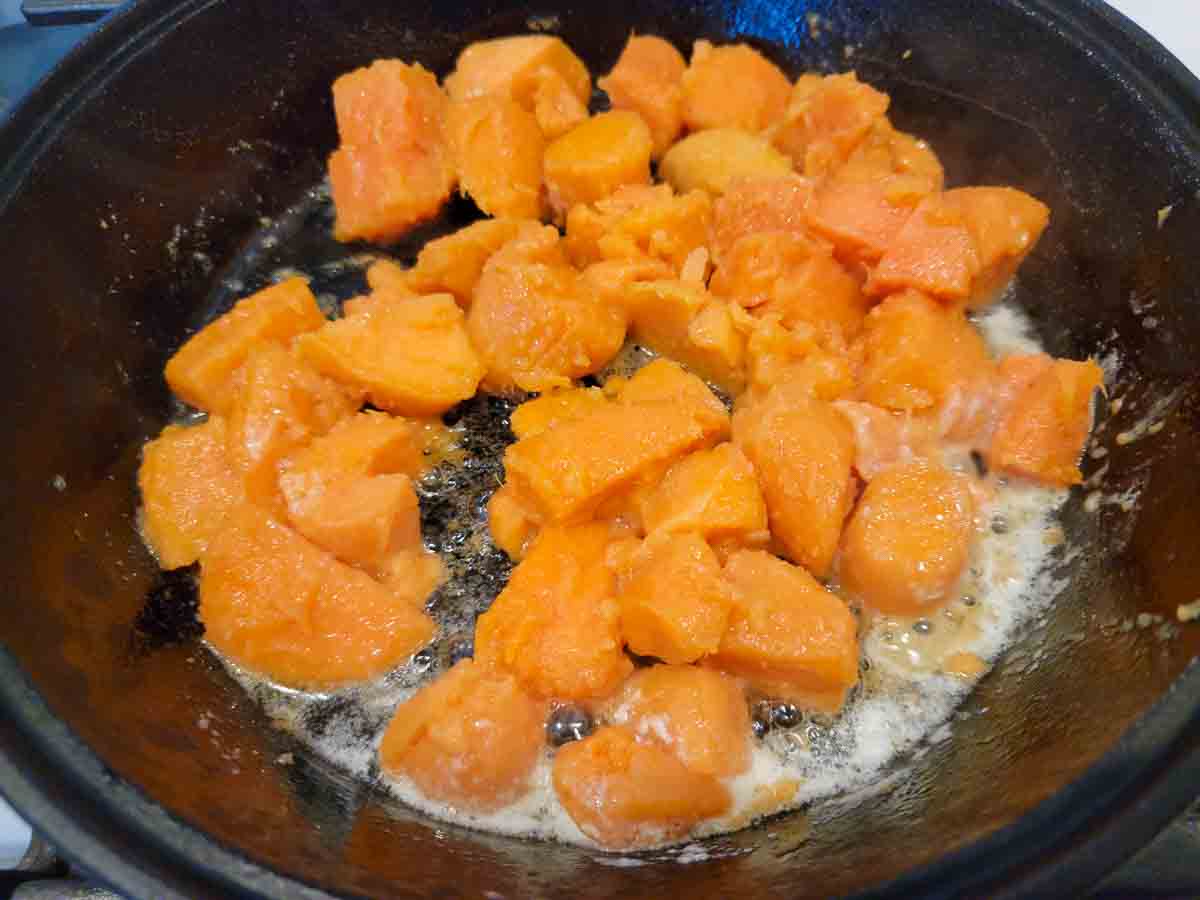 chopped sweet potatoes cooking in a skillet.