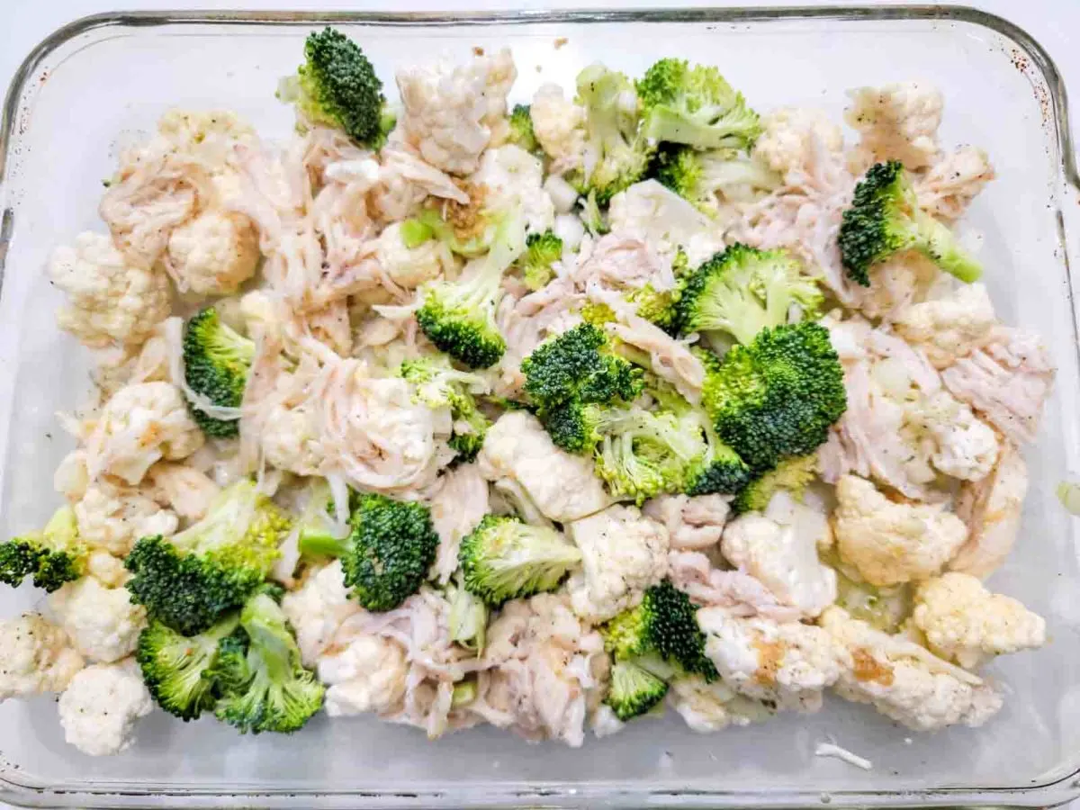 the rotisserie chicken, broccoli, cauliflower, onion, and jarred minced garlic in a 9x13-inch ovenproof casserole dish.
