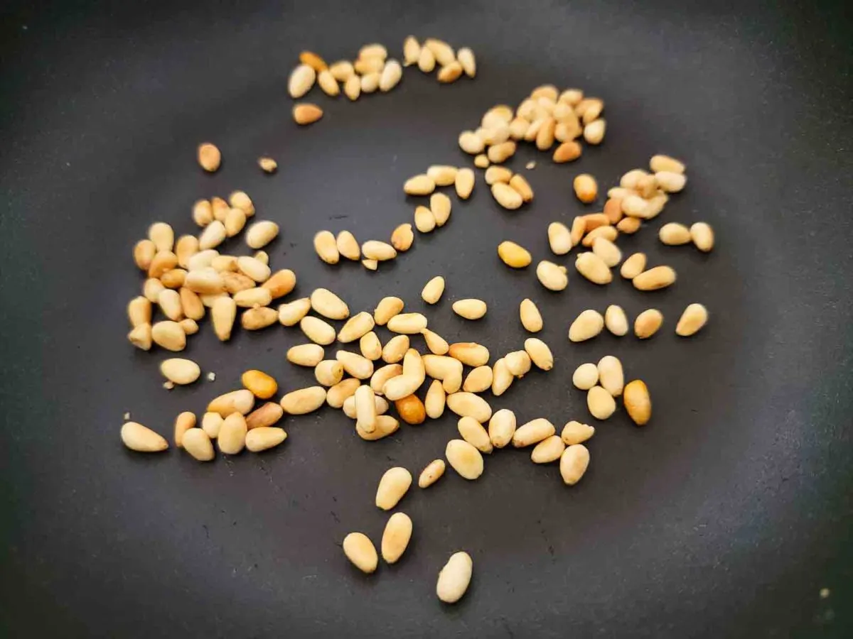 pine nuts cooking in a dry frying pan.