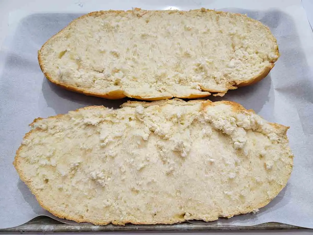 bread loaf sliced in half length wise on a baking sheet.