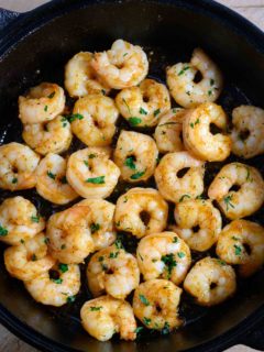 Honey Butter Old Bay Shrimp in a cast iron frying pan.