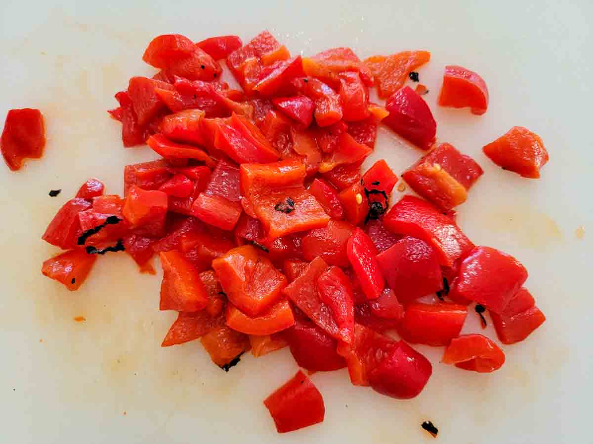 roasted red peppers diced on a cutting board.