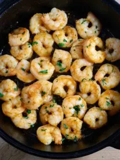 Honey Butter Old Bay Shrimp in a cast iron frying pan.